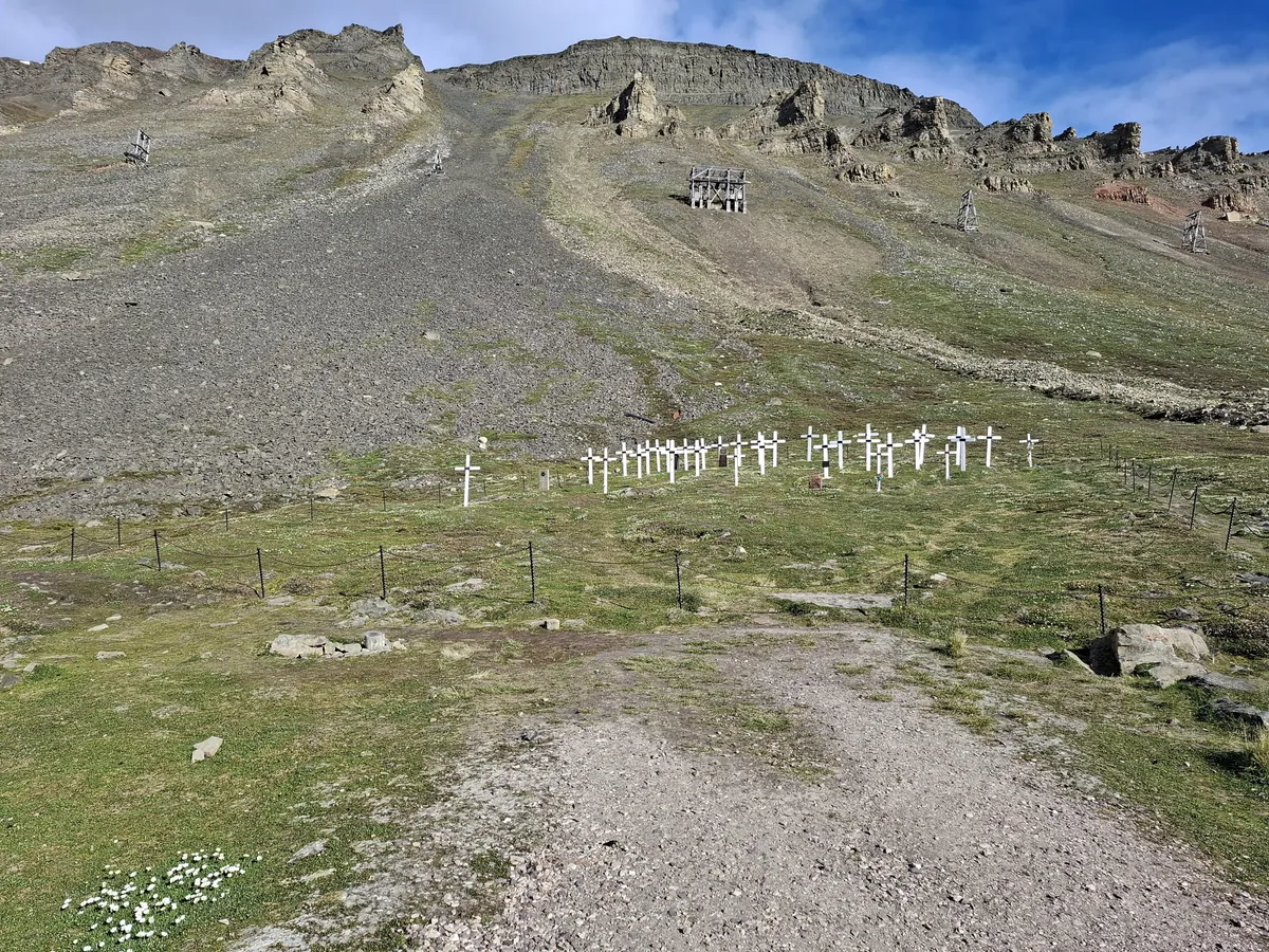 Rows of white wooden crosses on a hillside cemetery in Longyearbyen
